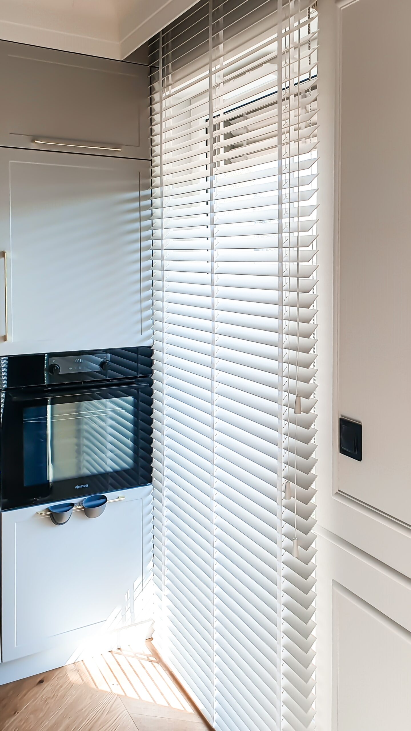 Biała żaluzja drewniana na wymiar w kuchni