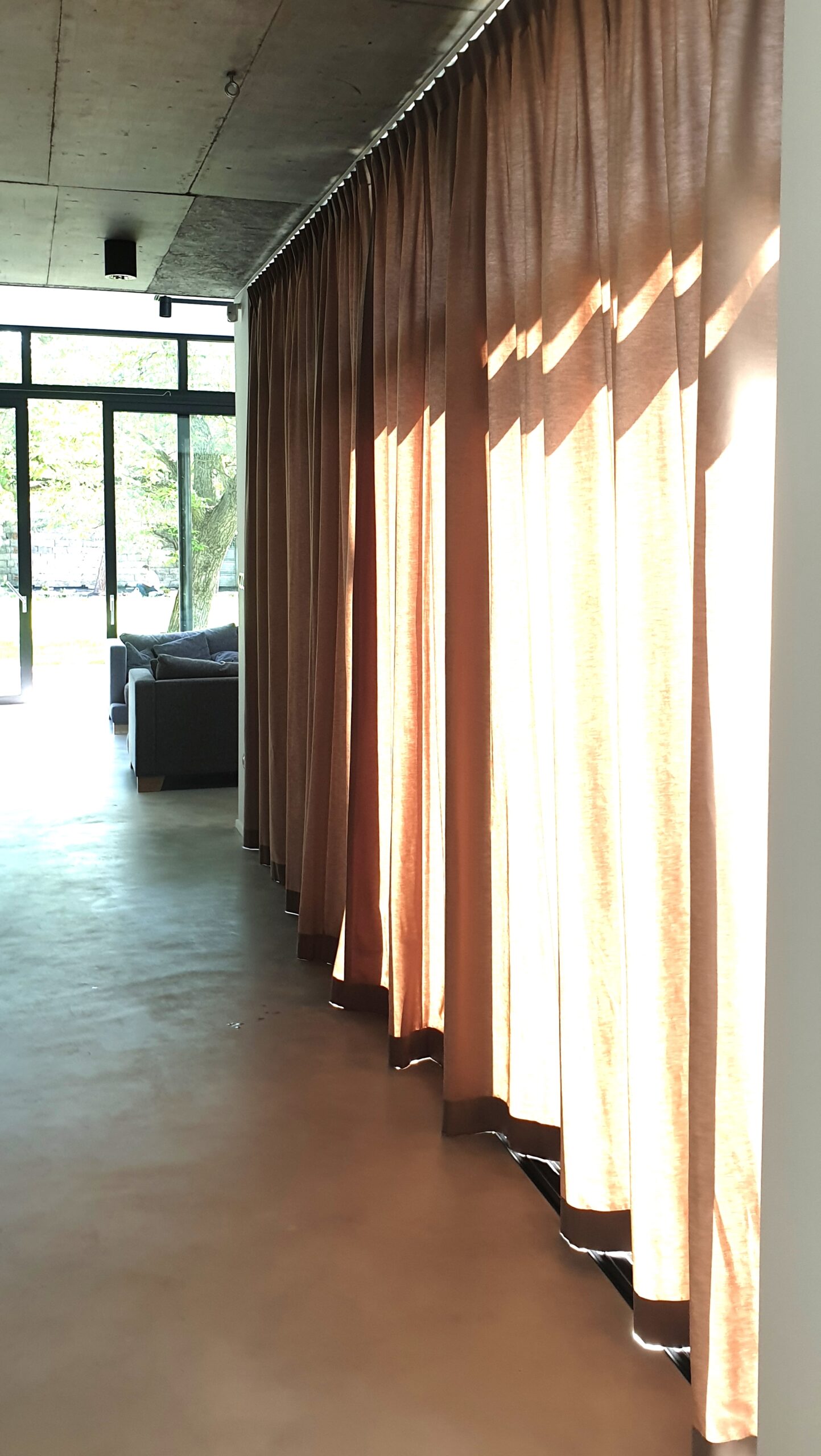 Zasłony w salonie z podłogą z mikrocementu